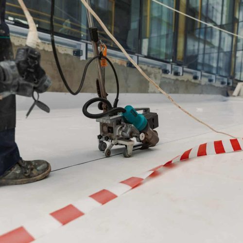 Worker welding pvc membrane by heater with welder machine
